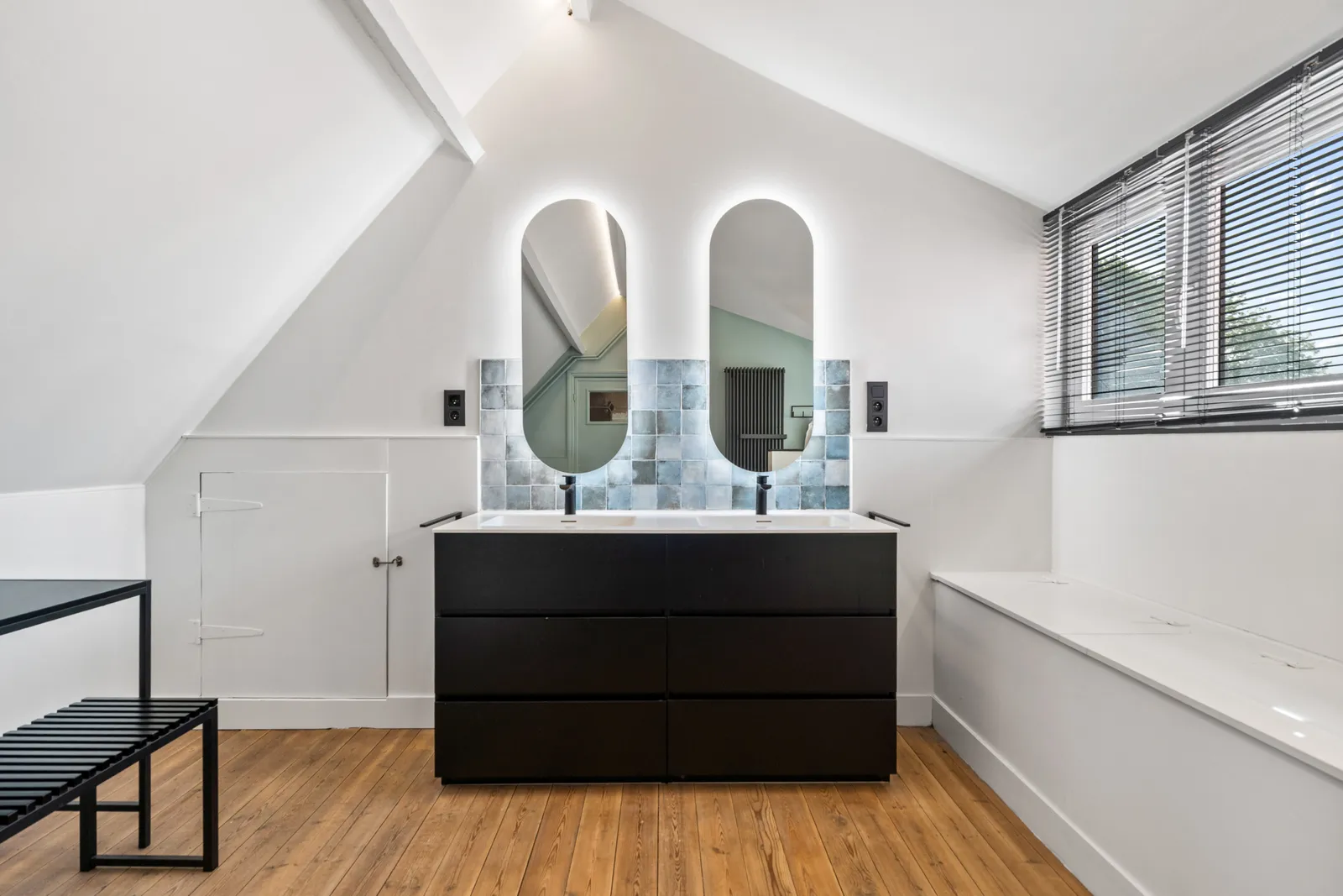 Badkamer met dubbele wastafel en ovale spiegels